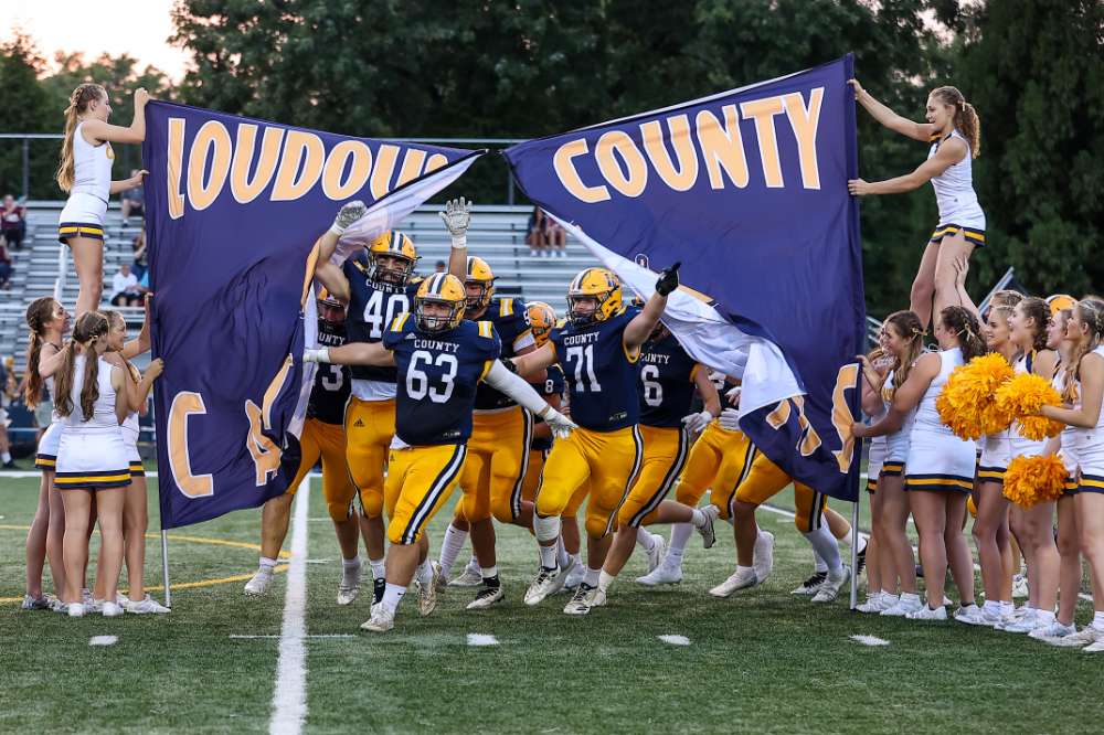 Loudoun County High School football team breaking through breakaway banner
